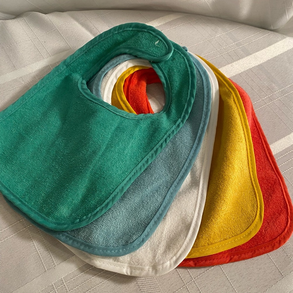 Set of five soft terry baby bibs. Velcro close. Green blue white yellow orange